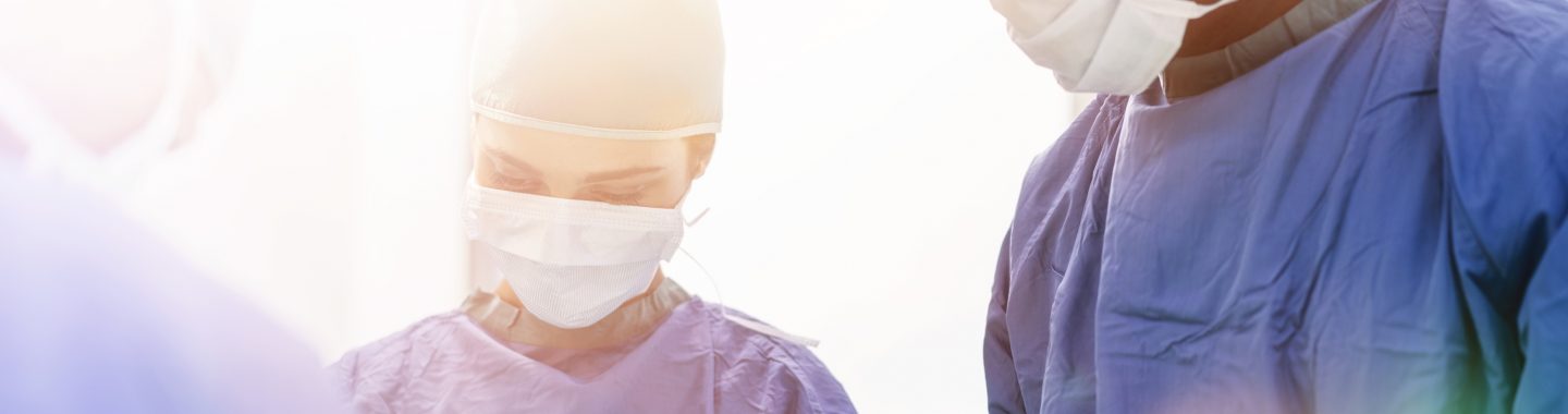 3 doctors with face masks on working on patient